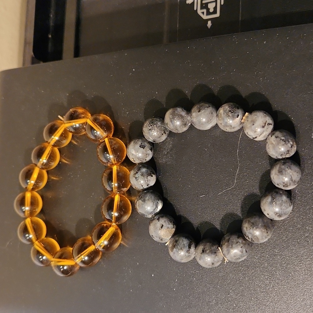 Two stretch band bracelets one grey 0ne goldish color. See pgotos